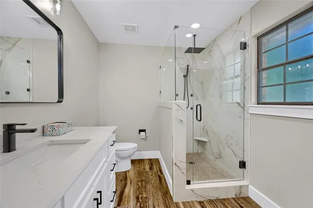 a bathroom with a sink a toilet and shower