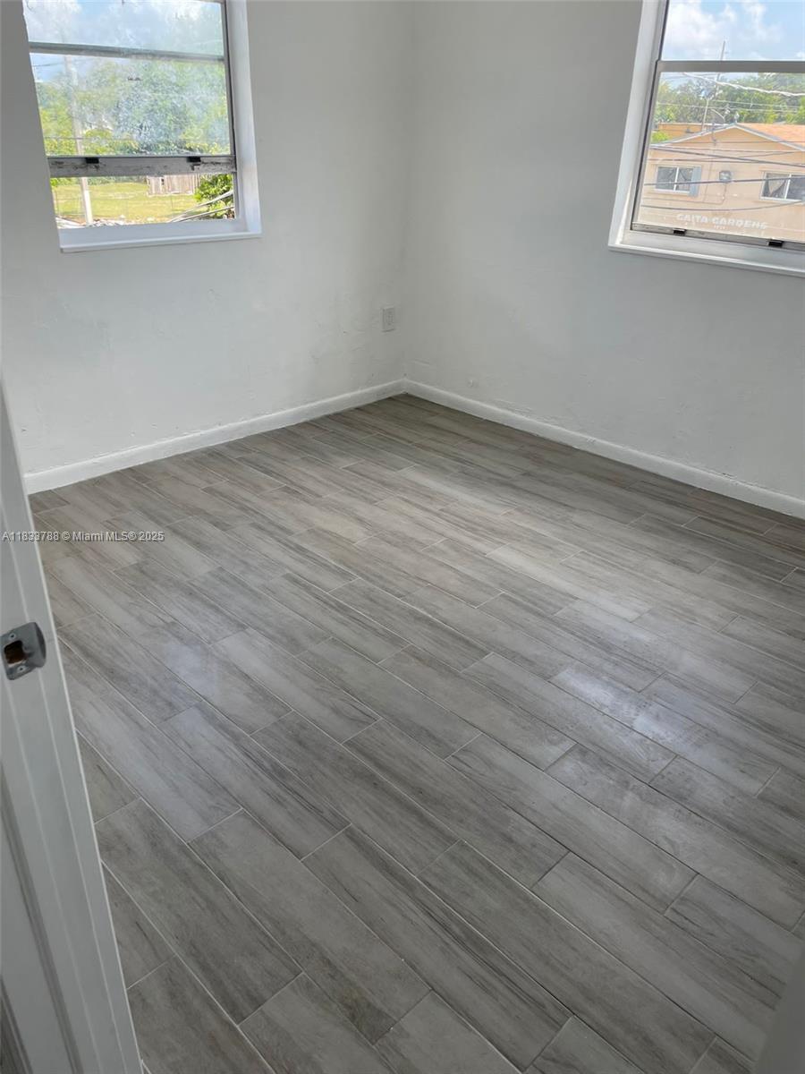 1261 Northwest 59th Street, Unit 5 Miami, FL 33142 - Photo 4 of 7 an empty room with a window