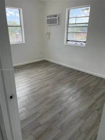 a view of a room with wooden floor and white walls