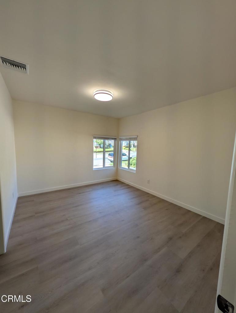4024 Monterey Road Los Angeles, CA 90042 - Photo 7 of 13 an empty room with wooden floor and windows