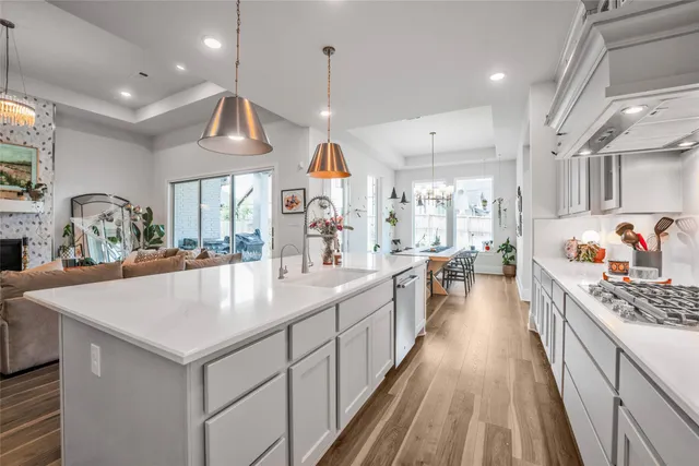 a large kitchen with kitchen island a large counter space a sink appliances and cabinets