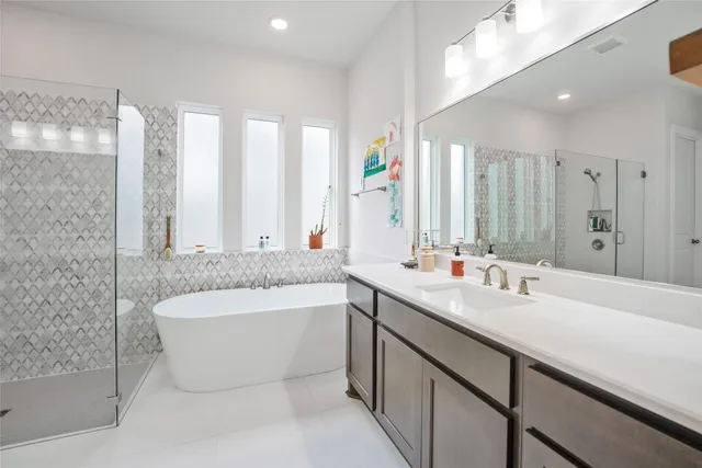 a bathroom with a double vanity sink a mirror and a bathtub