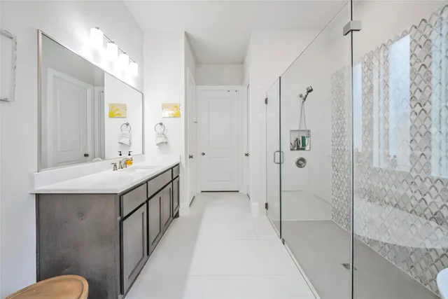 a bathroom with a double vanity sink mirror and shower