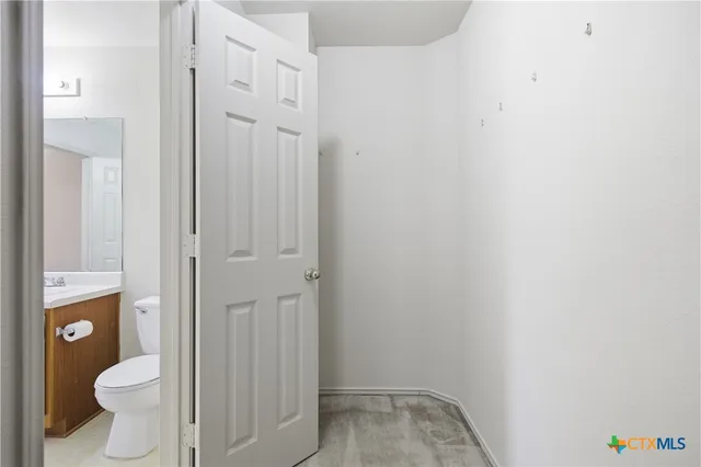a bathroom with a granite countertop toilet and a sink