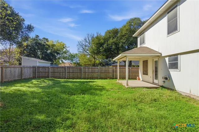 a view of a house with a yard and sitting area