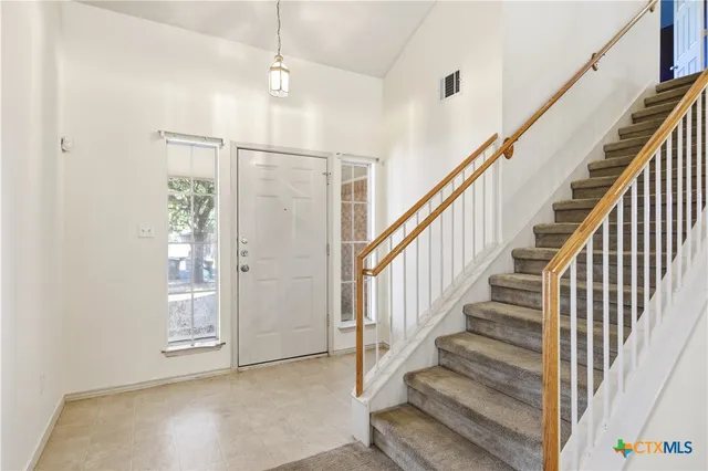 a view of staircase with lots of frames on wall and stairs