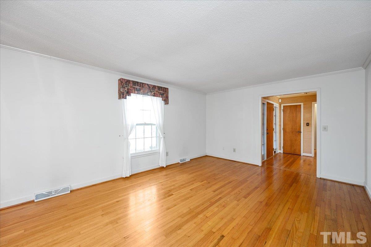 8913 Oneal Road Raleigh, NC 27613 - Photo 17 of 39 a view of empty room with wooden floor and fan
