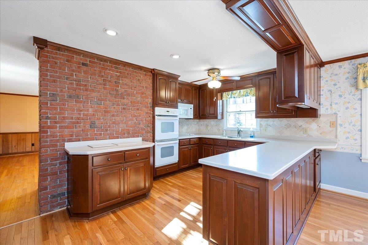 8913 Oneal Road Raleigh, NC 27613 - Photo 21 of 39 a kitchen with stainless steel appliances granite countertop a stove a sink dishwasher and a microwave oven with wooden floor