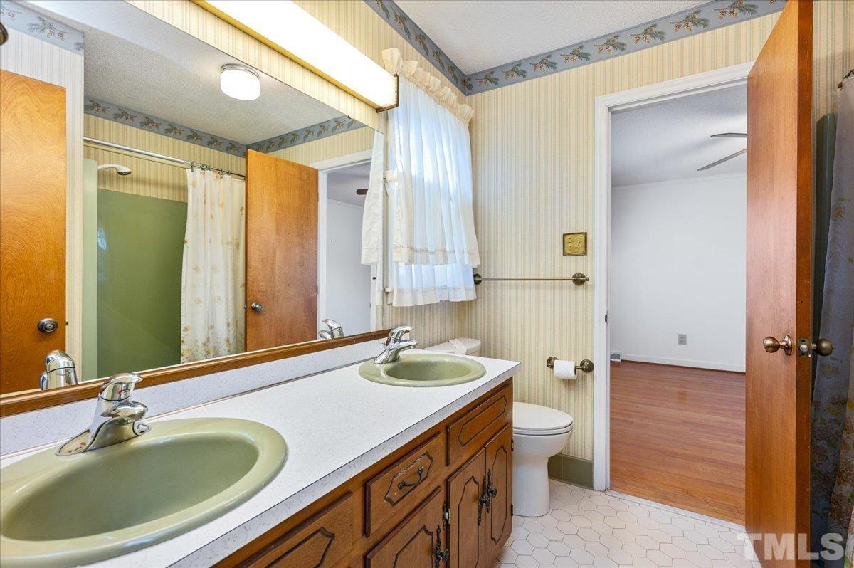 8913 Oneal Road Raleigh, NC 27613 - Photo 32 of 39 a bathroom with a granite countertop sink and a mirror