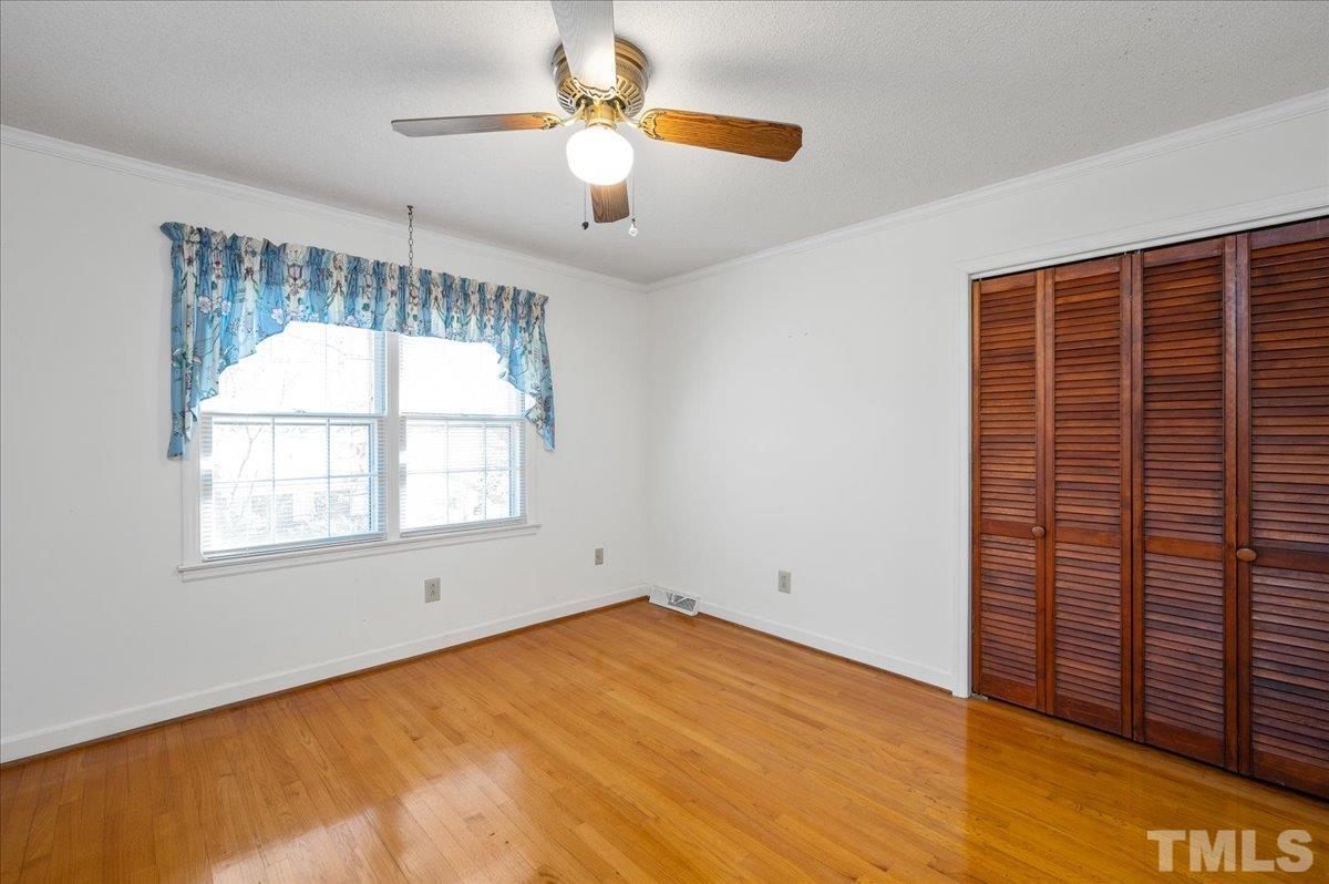 8913 Oneal Road Raleigh, NC 27613 - Photo 33 of 39 an empty room with a chandelier fan and windows