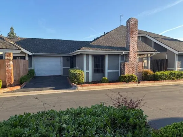 a front view of house with yard and trees around