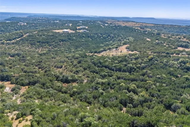 an aerial view of house with yard and mountain view in back
