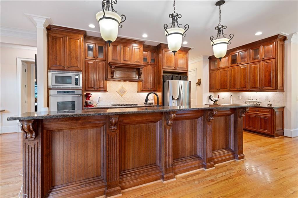 1750 Cone Flower Way Suwanee, GA 30024 - Photo 11 of 58 a kitchen with stainless steel appliances granite countertop wooden cabinets a refrigerator and a sink