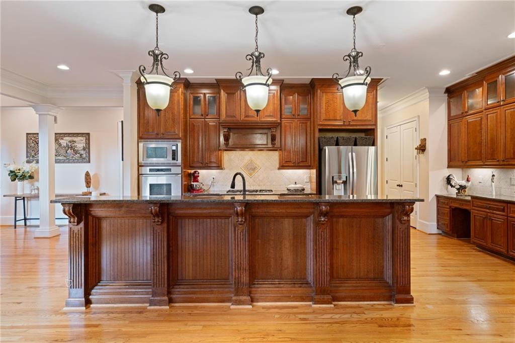 1750 Cone Flower Way Suwanee, GA 30024 - Photo 12 of 58 a kitchen with stainless steel appliances granite countertop a sink a stove and a wooden floor