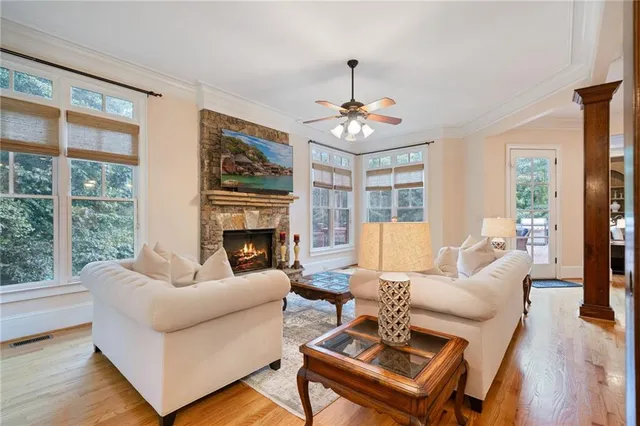 a living room with fireplace furniture and a large window