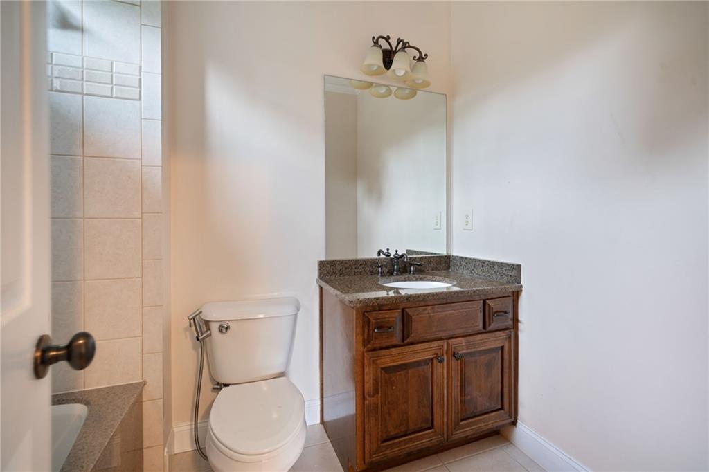 1750 Cone Flower Way Suwanee, GA 30024 - Photo 42 of 58 a bathroom with a granite countertop toilet sink and mirror