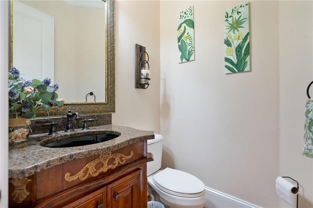 1750 Cone Flower Way Suwanee, GA 30024 - Photo 44 of 58 a bathroom with a granite countertop toilet sink and mirror