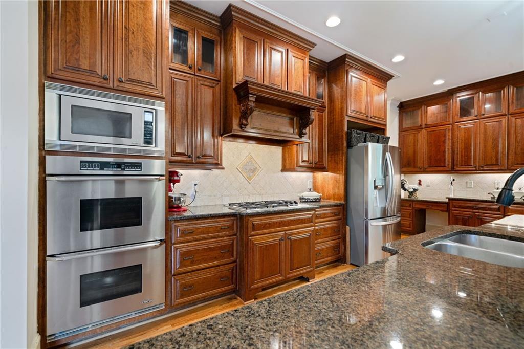 1750 Cone Flower Way Suwanee, GA 30024 - Photo 10 of 58 a kitchen with stainless steel appliances granite countertop a refrigerator stove and sink