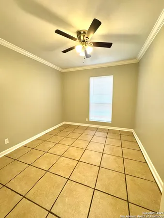 a view of a room with a ceiling fan and carpet