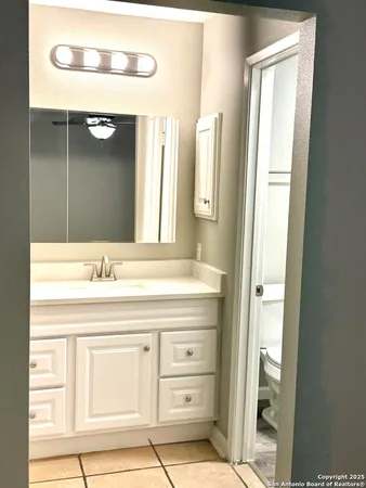 a bathroom with a granite countertop sink a mirror and a shower