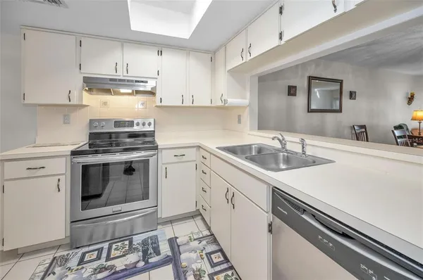 a kitchen with stainless steel appliances a refrigerator sink and cabinets