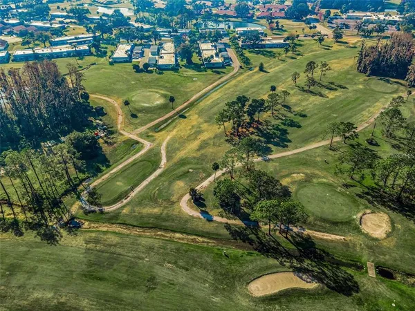 a dining room with wooden floor a chandelier a wooden table and chairs