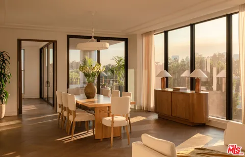a view of a dining room with furniture and large windows