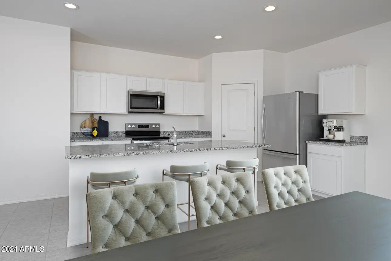 47884 West Cansados Road Maricopa, AZ 85139 - Photo 14 of 17 a kitchen with stainless steel appliances granite countertop a refrigerator and a stove top oven