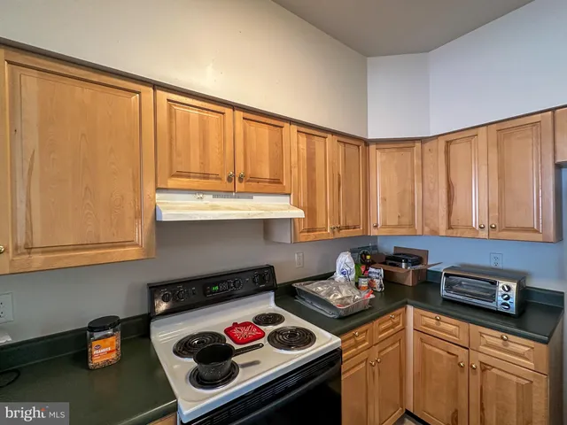 a kitchen with a stove a sink and cabinets