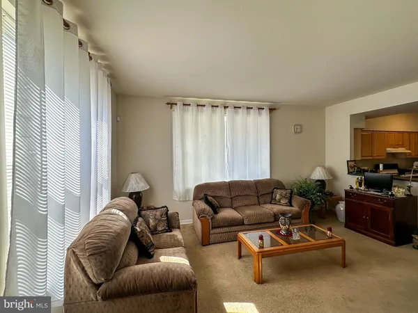 a living room with furniture ceiling fan and a window
