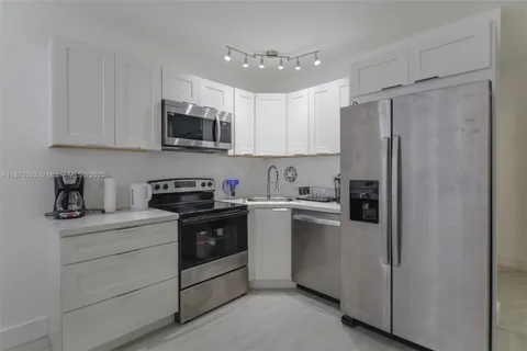 a kitchen with stainless steel appliances granite countertop a refrigerator sink and stove
