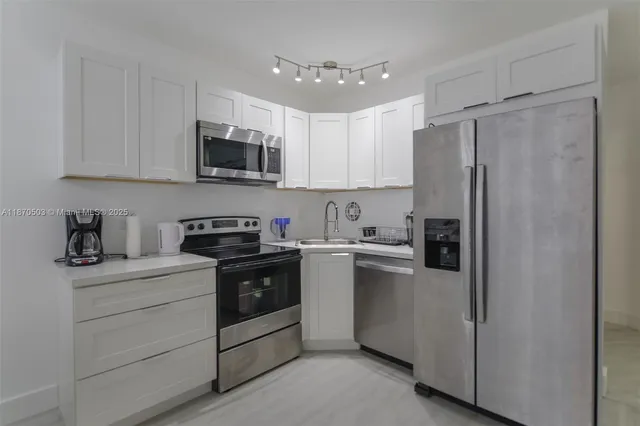 a kitchen with stainless steel appliances granite countertop a refrigerator sink and stove