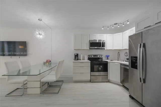 a kitchen with granite countertop a refrigerator and a stove top oven