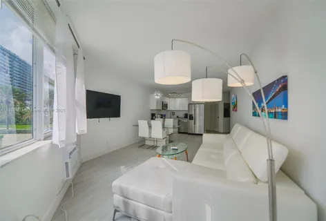 a living room with furniture a flat screen tv and a large window