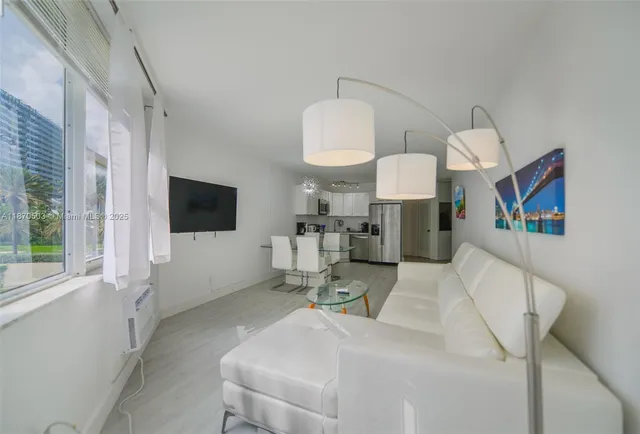 a living room with furniture a flat screen tv and a large window