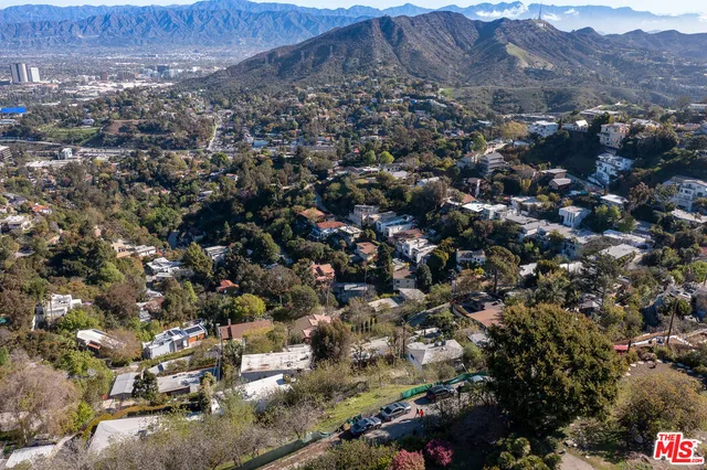 an aerial view of house with yard and mountain view in back