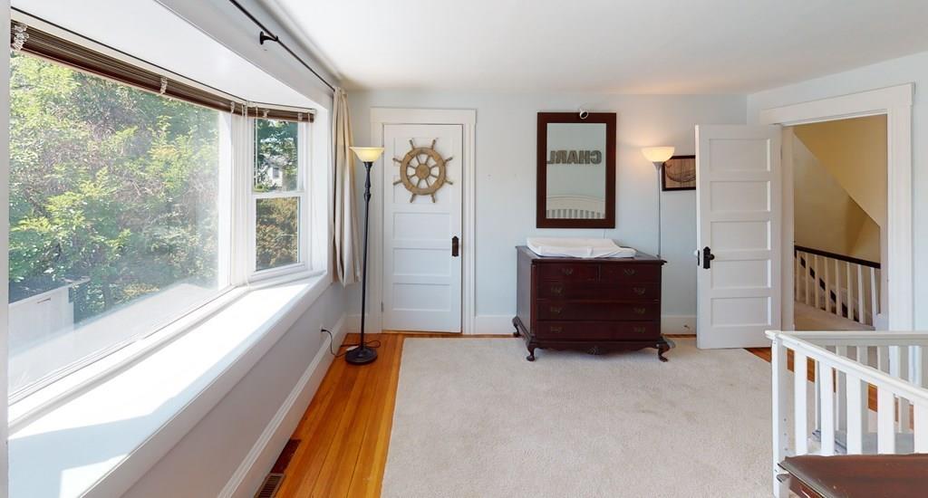 89 Spring Street Stoneham, MA 02180 - Photo 13 of 29 a living room with a balcony a bed and a large window