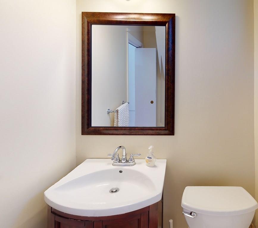 89 Spring Street Stoneham, MA 02180 - Photo 18 of 29 a bathroom with a toilet a sink and mirror