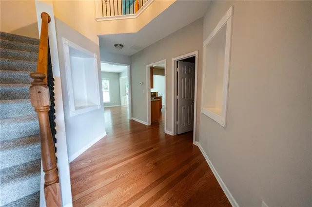 a view of a hallway with wooden floor and staircase