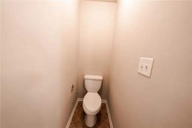 a white toilet sitting next to a white wall
