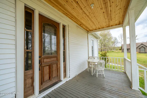 a view of a balcony with chairs and wooden floor