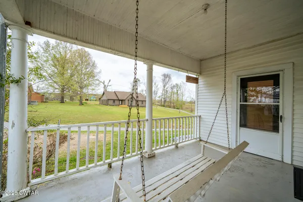 a view of an house with backyard and a tree