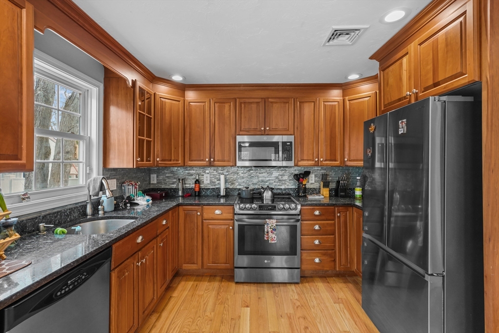 79 Coral Road North Attleboro, MA 02760 - Photo 2 of 14 a kitchen with stainless steel appliances granite countertop wooden cabinets a refrigerator a sink a stove a microwave and wooden floors