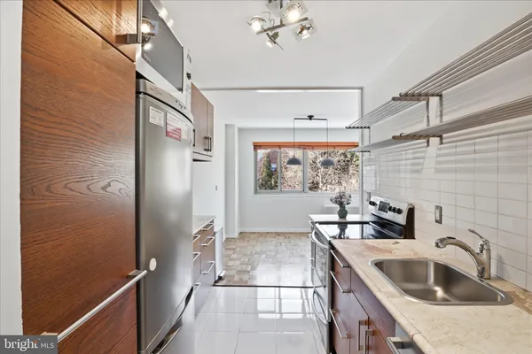 a kitchen with stainless steel appliances granite countertop a sink and a refrigerator