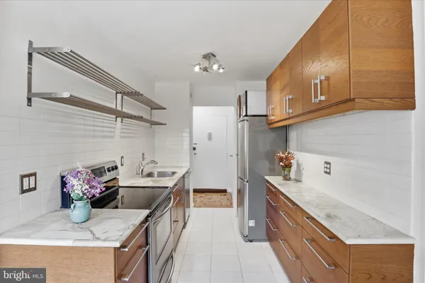 a kitchen with granite countertop kitchen island stainless steel appliances a sink stove and refrigerator