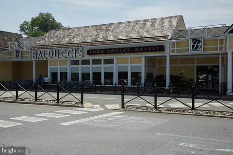 a building exterior with a chair and tables