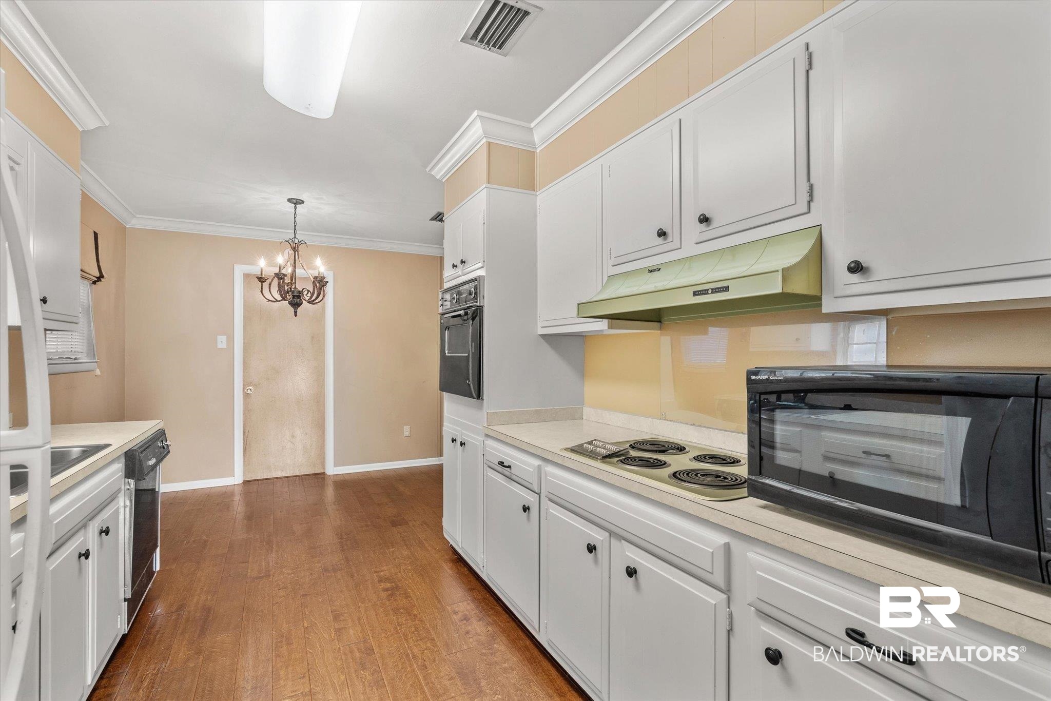 5608 Judson Circle Mobile, AL 36608 - Photo 4 of 20 Kitchen with pendant lighting, white cabinetry, a chandelier, black appliances, and wood-type flooring