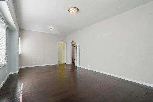 an empty room with wooden floor and window