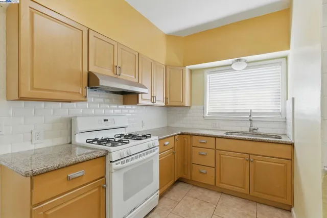 a kitchen with cabinets appliances a sink and a window