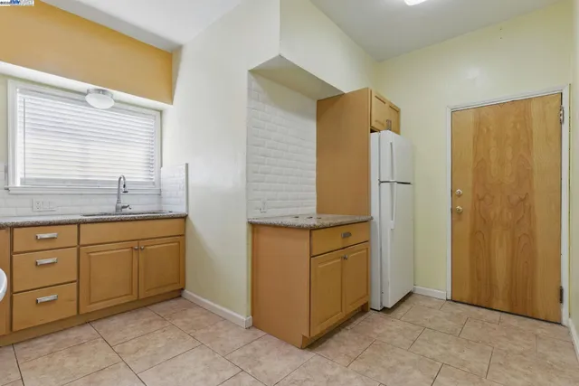 a kitchen with granite countertop cabinets and refrigerator
